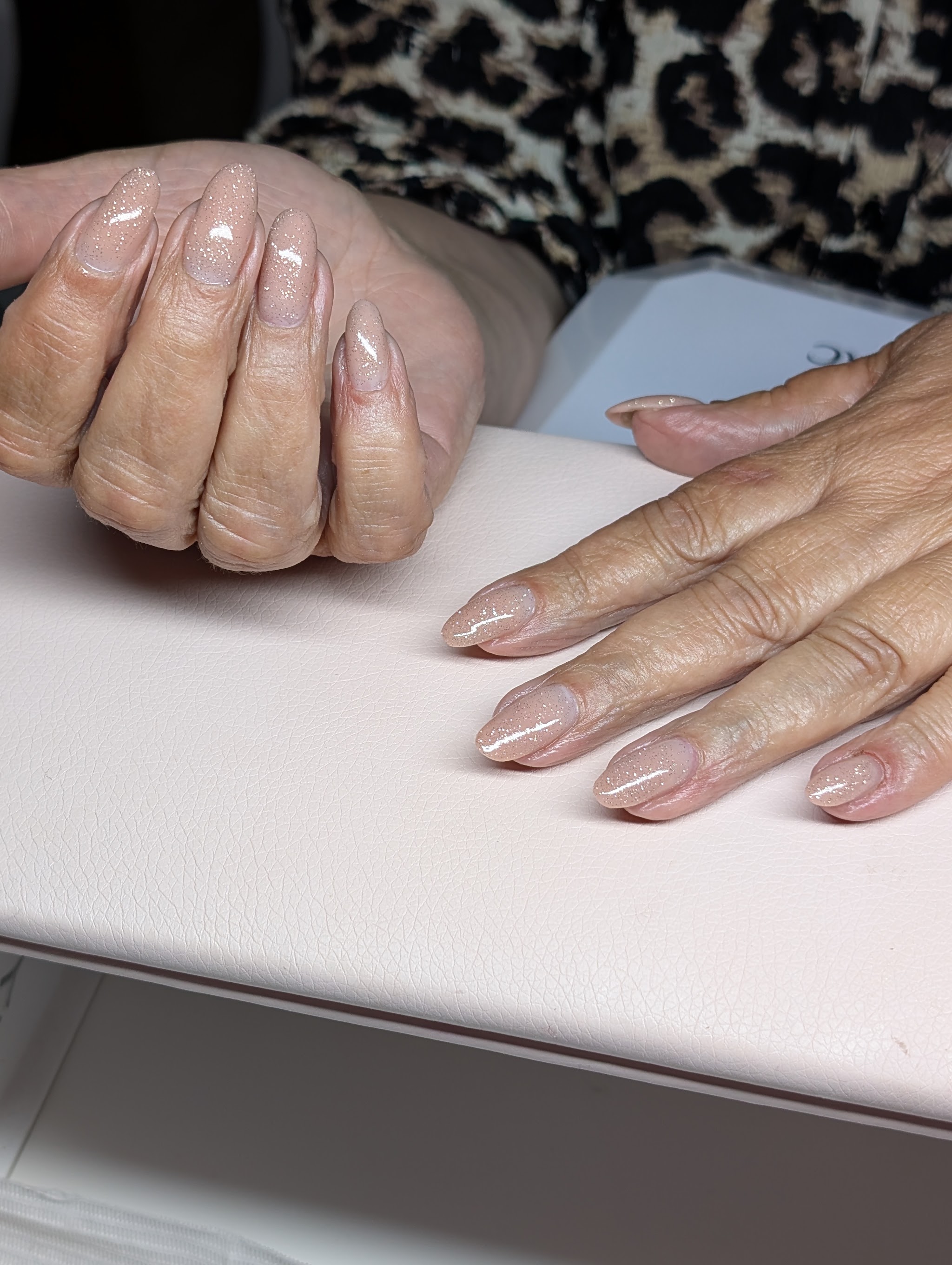 Lange amandelvormige nagels in nude met glitter, gezet door Ela