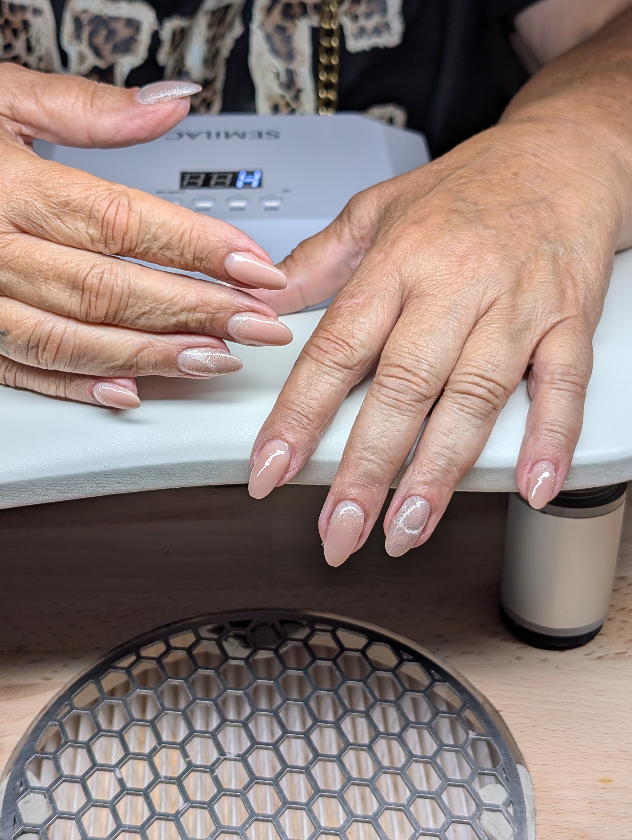 Nude amandelnagels onder de lamp in de salon